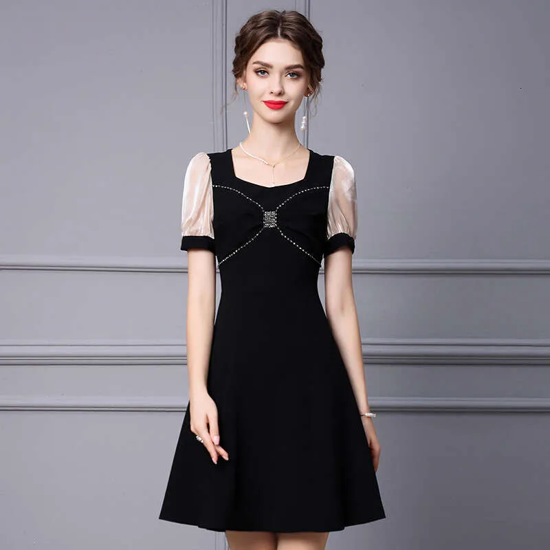 Elegant Black knee-length dress with peach-colored panels and silver embellishments.