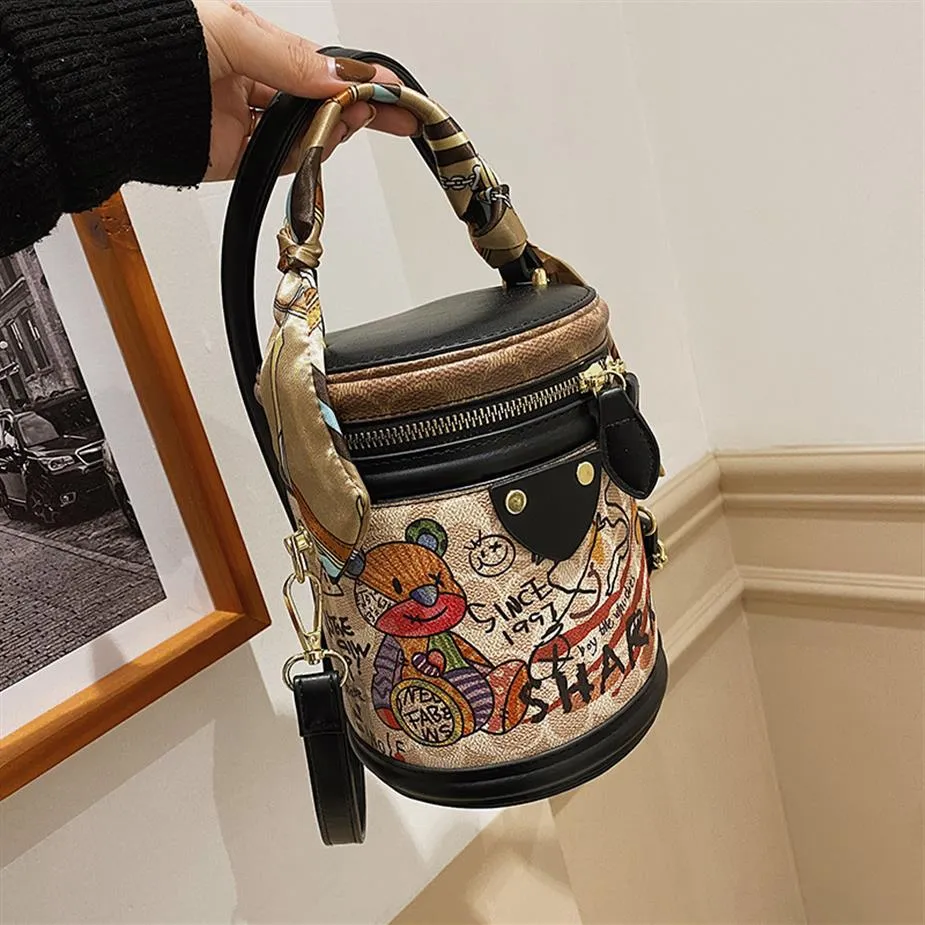 Bolsas de ombro de fábrica inteira de fábrica doce uso fofinho de urso de graffiti saco de caçamba de tendência de tendência feminina fita handbag europeu Pop310y