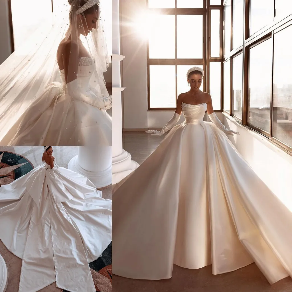 Royal Ivory Satin Dubai Arabskie sukienki ślubne Seksowne koraliki bez ramiączki bez pleców Ruche długie pociągnięcie ślubne suknie ślubne z dużym łukiem