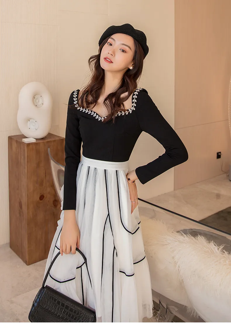 Elegant Black and White Floor-Length Dress with Fitted Top and Full Skirt.