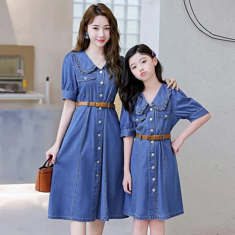 denim dress family photos young mother with daughters dressed in denim dresses. Family look. Happy family Stock Photo