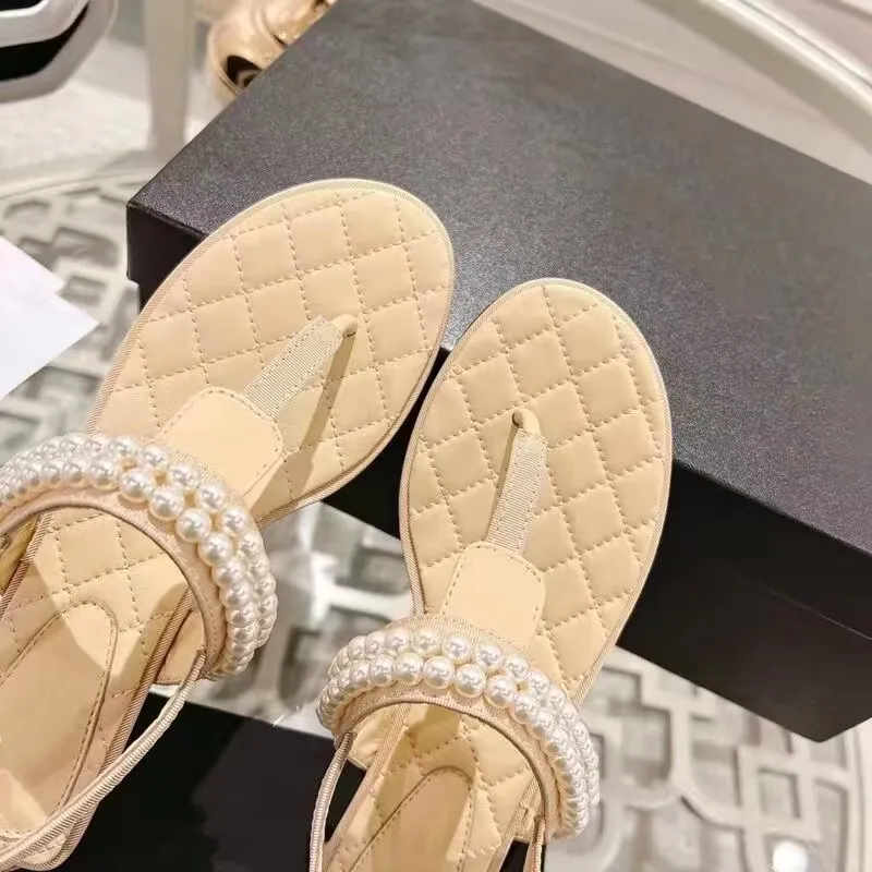 Fransk designer Kvinnor Tofflor Klipptå Platt pärla Sandaler Sommar T Knutna Damskor Strand Casual Kvinna lyx c Flip Flops Mode Kvinnligt Läder