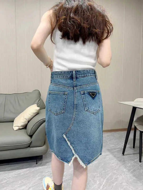 Designer de saias 2023 primavera/verão nova cintura alta assimétrica borda crua saia jeans dividida casual curta roupa feminina 31QZ