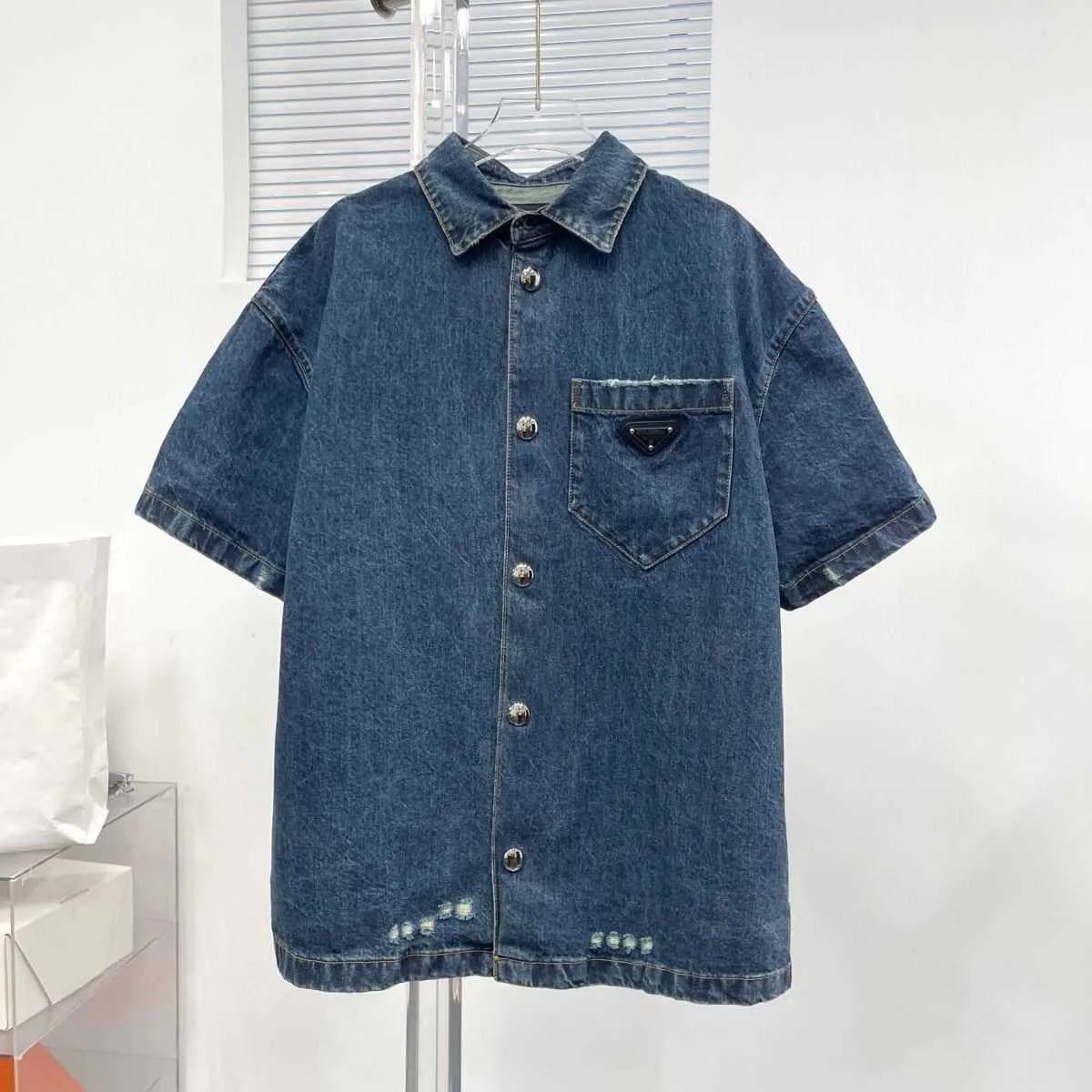 Veste de chemise à manches courtes en denim à revers bleu d'été, trou en denim décontracté, version ample des hommes et des femmes de la même chose.