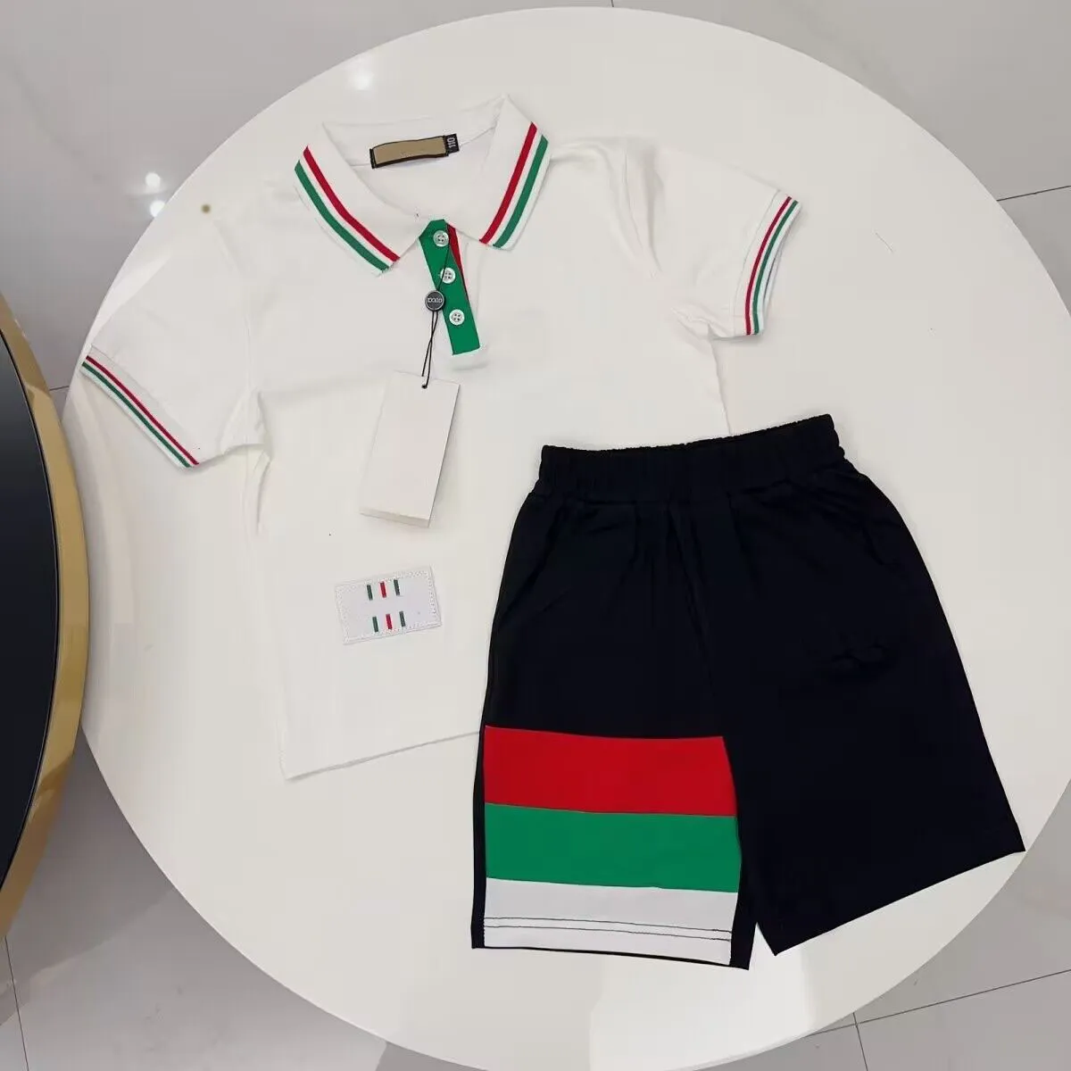 夏の新しい子供向けスーツの短袖ポロシャツとショートパンツの韓国語バージョンカジュアルファッションクラシックチルドレンズ衣料西部スタイル。
