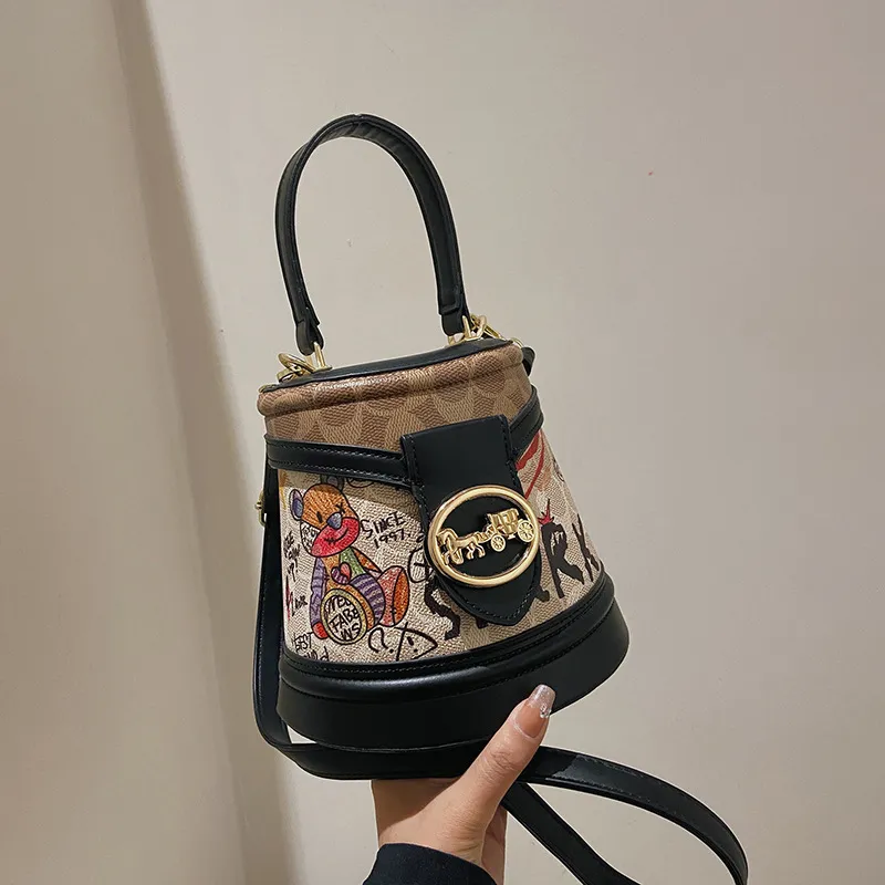 Factory wholesale ladies shoulder bags 2 colors street popular totem bucket bag trend western-style printed handbag thickened leather mobile phone coin purse 2210