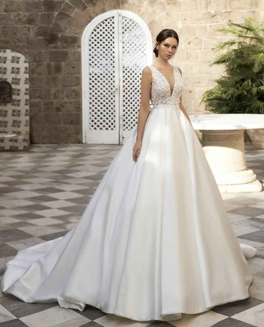 2024 Elegant A Line Satin Wedding Dress Lace Appliques Pärlade ärmlösa långa brudklänningar V-Neck Empire Midja Classic White Bride Dresses Court Train