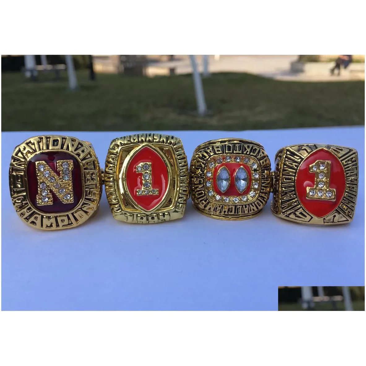 Cluster Rings 4Pcs 1983 1994 1995 1997 Nebraska Cornhuskers National Championship Ring With Wooden Display Box Men Fan Gift Wholesale Dhibc