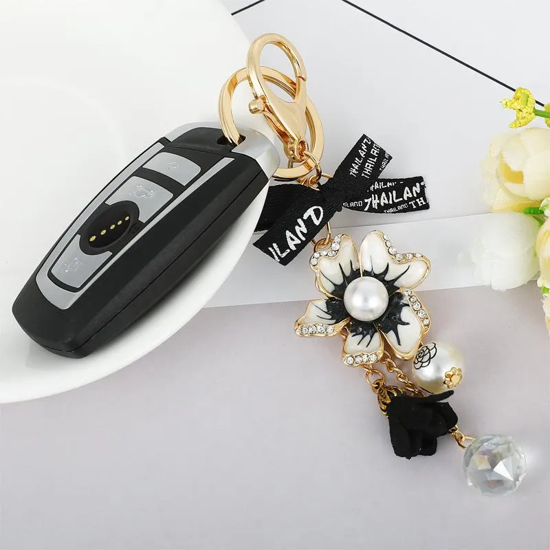 Porte-clés créatif strass perle camélia alliage porte-clés arc fleur Couple pendentif porte-clés