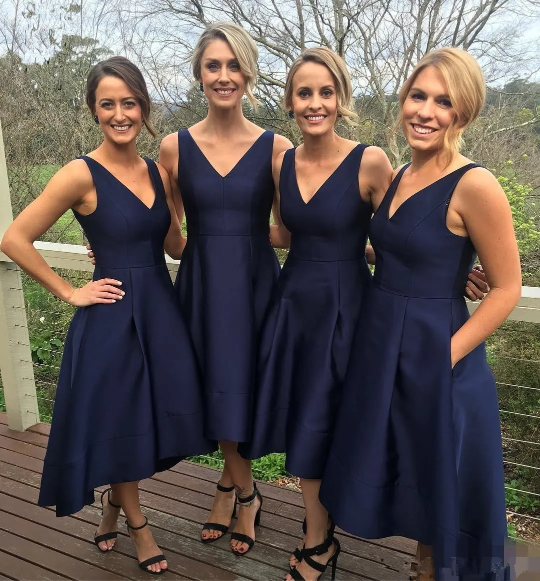 Hoge lage bruidsmeisjesjurk met zakken A-lijn thee Lengte Dark Navy Satin Simple Wedding Guestjurken Korte voorkant V-Neck Mouwloze prom feestjurken voor vrouwelijke meisjes