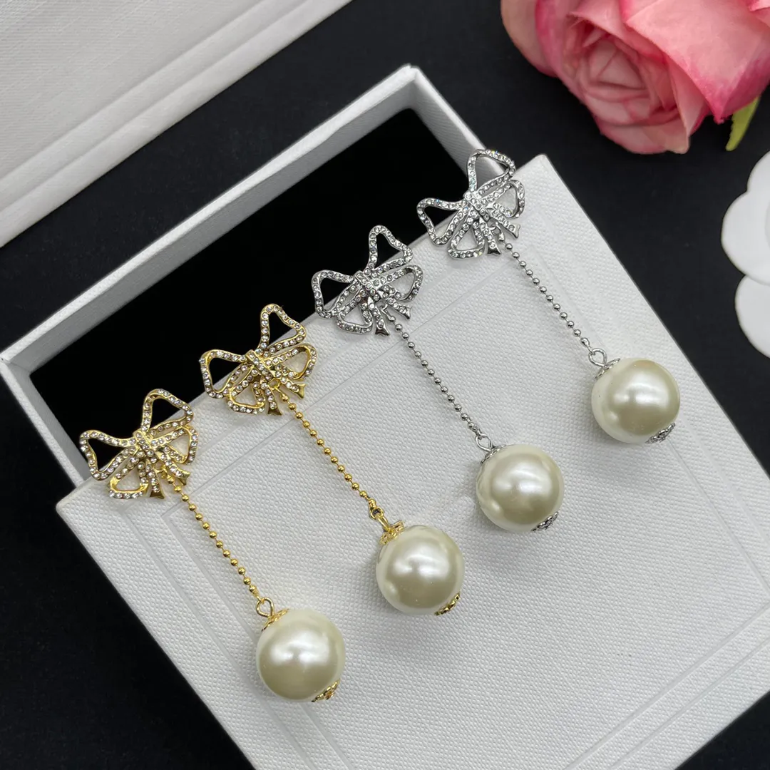 Vrouwen modeontwerper stud gouden zilveren bowknot oorbellen witte parel eenvoudige stijl messing engagement lange oorrel