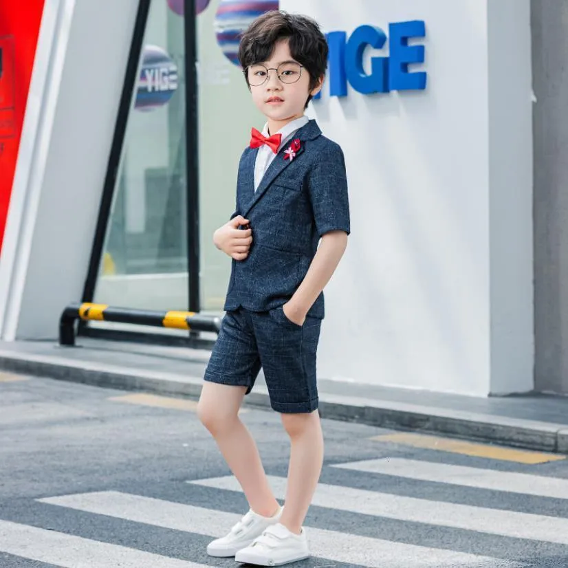 Un niño de 2 años con camisa y chaqueta se para en la calle traje clásico  infantil para las vacaciones moda infantil