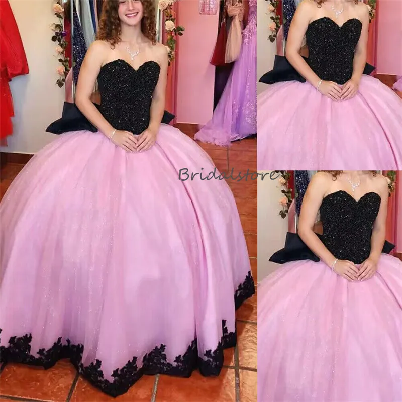 Rosa scintillante con abiti Quinceanera neri 2023 Abito da dolce 15 in pizzo con paillettes con fiocco grande Principessa Compleanno Occasioni formali Abiti Debuttanti Ballo in maschera