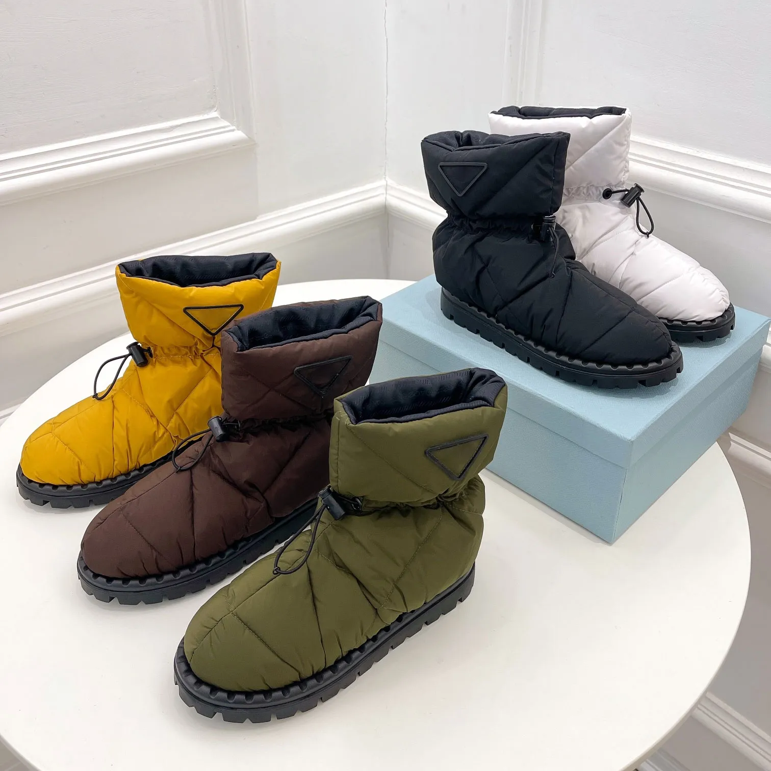 Après-skischoenen van nylon gabardine Zwart bovenwerk met trekkoord Uitneembare gewatteerde voering Snowboots met driehoekig logo Rubberen zool Designer skischoenen