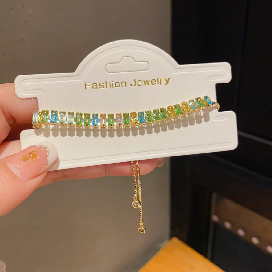 Braccialetti con cristalli baguette arcobaleno color oro e dettagli sfumati colorati, scintillanti per uno stile da polso quotidiano o glamour._voghion.com