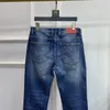 Créateur de mode Designer de vêtements pour hommes Plaque signalétique en cuir Denim Slim jambe droite Jeans haut de gamme déchiré moto coupe slim pour hommes et femmes pantalons de moto