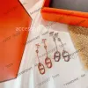 Pendientes de joyería de diseñador Pendientes colgantes de lujo Marca Redonda Nariz de cerdo Diseñador Top V Cubo de oro Cruz Encanto Cadena larga Borla Pendientes colgantes para mujer