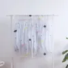 Boîtes de rangement cache-poussière pour les vêtements de la chambre suspendus à un cintre au sol pour les garder à l'épreuve de l'humidité.