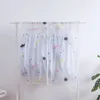 Boîtes de rangement cache-poussière pour les vêtements de la chambre suspendus à un cintre au sol pour les garder à l'épreuve de l'humidité.