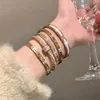 Un bracelet Cartres classique Bracelet en acier titane zircon plaqué or véritable pour femme à la mode simple et haut de gamme avec un charme polyvalent unique