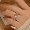 Uciekająca księżniczka trzyma pierścionek z diamentem kwiatowym i otwarty pierścień z jednego karatowego z mosonitu. Wysokiej i wszechstronnej róży obrączki wynosi 579