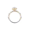 Uciekająca księżniczka trzyma pierścionek z diamentem kwiatowym i otwarty pierścień z jednego karatowego z mosonitu. Wysokiej i wszechstronnej róży obrączki wynosi 223