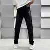 Мужские джинсы Дизайнер Гуанчжоу Xintang Cotton Bullet Корейское издание Slim Fit Высококачественная европейская черная мужская одежда с принтом Medusa X082