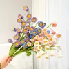 Fiori decorativi che vendono bouquet di mughetto intrecciato a mano, fiori di simulazione, ornamenti lavorati a maglia tenuti in mano, decorazioni per la casa