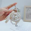 Korean version of pearl string camellia key chain petal personality bag key chain hanging decoration high appearance level car couple key chain