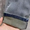 Högkvalitativa män jeans designer jeans män kvinnor metall triangel byxor mode casual smala raka byxor hög ände tvättad denim