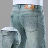 남자의 청바지 디자이너 라이트 럭셔리 트렌디 한 청바지는 슬림 한 핏과 작은 발을 가진 남성을위한 고급 트렌디 한 청바지, 한국의 탄성 수 놓은 직선 튜브 블루 남자 바지 yyf6의 한국 버전