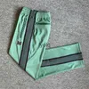 Pantalones para hombres Agujas de rayas púrpuras Pantalones de chándal verdes Hombres Mujeres Bordado Mariposa AWGE Cordón Trackyolq