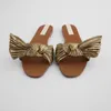 Chinelos Mulheres Sandálias Planas Verão 2024 Moda Golden Round Toe Bow Sexy Outer Wear e Beach Luxury