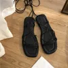Sandaler sandaler kvinnor sommar ny 2024 strand mode sexig platt casure cross-tie öppen tå sagan smala band skor svart Rom Sandalsl2401
