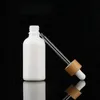 Flacon compte-gouttes d'huile essentielle blanche de 10ml 15ml 30ml, récipient d'emballage de pipette en verre cosmétique avec couvercle en bambou à grain de bois cap1186T