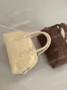 韓国のデザイナーブランドボストンバッグ、本物のレザーハンドバッグ、トートミニマリストの春と夏のファッショナブルで汎用性の高いハイエンドレザー通勤バッグクリームブラック