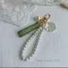 Porte-clés Designer Charme de luxe Bague féminine Perle Charme Ruban vert Coquilles délicates GGG Pendentif Cadeau 240303