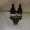 Le donne in costume da bagno sono un bikini conservatore a vita alta coperto con pancia sottile e aderente, con fettuccia divisa e triangolo nero, sexy, con piccolo petto raccolto