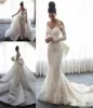 Abiti da sposa a sirena di lusso Collo trasparente Maniche lunghe Illusione Piena di applicazioni in pizzo Con gonna oversize con bottoni sul retro Abiti da treno con cappella F6451321