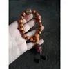 Bracciale in filo di osso di bue tenuto in mano con perline tibetane a tre occhi