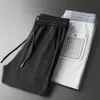 Pantaloni da uomo Light Luxury 2023 Primavera / Estate Marchio di moda Pantaloni casual ricamati Pantaloni da uomo in seta liscia e morbida Pantaloni sportivi di fascia alta J240328