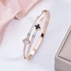 Version coréenne de l'acier inoxydable haut de gamme léger à la mode avec incrustation de diamants, bracelet double trèfle noir et blanc plaqué or pour femmes sans