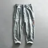 Pantalon masculin laver les jeans décontractés de l'eau de Javel entièrement enrôlé de denim en détresse vintage de cargaison de cargaison