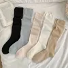 Calzini da donna pettinata per le calze a gamba a metà grigio e grigio autunno indossato con piccole scarpe in pelle fuori dalla strada