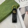 Högkvalitativ läder nyckelchain klassisk utsökt lyxig designer bil nyckelring zinklegering bokstäver män och kvinnors universella lanyard metall liten hänge topp11