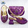 Sapatos de vestido maduros que próximos as mulheres italianas combinam bolsas com saltos finos e brilhantes para a festa do jardim em roxo