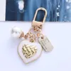 Keychains Bedanyards Fashion Pearl Heart Pinging Keychain Rose Flower Metal Plate Chans Key Caso de fones de ouvido Charms Bag Ornament Accessories Gifts J240509