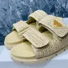 Berömda märken Flat Platform Slide tofflor flätade raffia komfort sandaler med signatur triangel öppna tår skor för kvinnor semester sandal fabrikskor