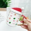 カップソーサークリスマスハットのふたとスプーンの手作りのファニーユニークな贈り物を添えたセラミックコーヒーマグ