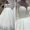 2022 Lyxig pärlstav kristallbröllopsklänningar prinsessa med illusion långa ärmar vit tyll ren halsringning ihålig bakkulklänning 193 år